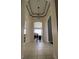 Inviting hallway featuring tray ceilings, archways, and light-colored tile leading into a bright, open living space at 5229 Clover Mist Dr, Apollo Beach, FL 33572