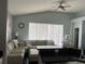Bright living room features a large sectional sofa, a ceiling fan, and sheer curtains providing soft, natural light at 5229 Clover Mist Dr, Apollo Beach, FL 33572