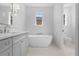 Elegant bathroom featuring a modern soaking tub, double windows and gray cabinets at 5337 6Th N Ave, St Petersburg, FL 33710