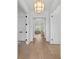 Bright hallway featuring hardwood floors, white trim, paneled doors, and decorative lighting at 5337 6Th N Ave, St Petersburg, FL 33710