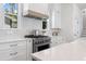 Modern kitchen with stainless steel oven and hood, white countertops, and white subway tile backsplash at 5337 6Th N Ave, St Petersburg, FL 33710