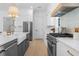 Stylish kitchen featuring stainless appliances, farmhouse sink, gray island, and white cabinets with gold hardware at 5337 6Th N Ave, St Petersburg, FL 33710