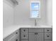 Bright laundry room featuring gray cabinets, white countertops and a window providing natural light at 5337 6Th N Ave, St Petersburg, FL 33710