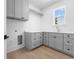 Bright laundry room with gray cabinets, sink, and hardwood floors at 5337 6Th N Ave, St Petersburg, FL 33710
