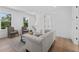 Bright living room with hardwood floors, two armchairs, and a white sofa with natural light from two windows at 5337 6Th N Ave, St Petersburg, FL 33710