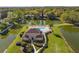Stunning aerial view of a lakeside property with a swimming pool, lush lawns, and mature trees at 7440 Mint Julep Dr, Riverview, FL 33578