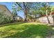 Large grassy backyard featuring a mature tree and screened in patio at 7440 Mint Julep Dr, Riverview, FL 33578