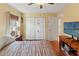 Bedroom boasts wood floors, a ceiling fan, a window with blinds, a double door closet, and a neutral color scheme at 7440 Mint Julep Dr, Riverview, FL 33578
