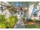 Inviting front entrance featuring double doors, complemented by lush landscaping and a charming chair at 7440 Mint Julep Dr, Riverview, FL 33578