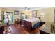Comfortable bedroom showcasing hardwood floors, a ceiling fan, two windows, and simple furnishings at 7440 Mint Julep Dr, Riverview, FL 33578
