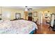 Spacious main bedroom features hardwood floors, a ceiling fan, an ensuite bathroom, and simple furnishings at 7440 Mint Julep Dr, Riverview, FL 33578