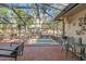 Enclosed patio featuring a brick surface, spa, comfortable seating, ceiling fan and decorative accents at 7440 Mint Julep Dr, Riverview, FL 33578