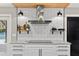 Stylish kitchen with white cabinetry, subway tile backsplash, open shelving, stainless steel range hood, and modern appliances at 1013 Newberger Rd, Lutz, FL 33549