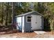 Exterior shot of shed with white door, wood siding, and a small ramp for easy access at 1013 Newberger Rd, Lutz, FL 33549