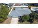 Aerial view of the property displaying the home's layout, roof, driveway, and surrounding landscape at 10915 Hammock Dr, Largo, FL 33774