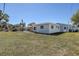 Backyard view showing a house with a covered patio and a well-maintained lawn at 10915 Hammock Dr, Largo, FL 33774