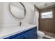 Modern bathroom features a blue vanity, quartz countertop, and tiled shower at 10915 Hammock Dr, Largo, FL 33774