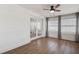 Bedroom featuring light, neutral walls, wood-look floors, a ceiling fan, and natural light from the windows at 10915 Hammock Dr, Largo, FL 33774