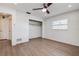 Bedroom has wood-look floors, a ceiling fan, a closet, and a window for natural light at 10915 Hammock Dr, Largo, FL 33774