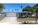 Beautiful home with a large garage and a driveway, nestled on a lush green lawn at 10915 Hammock Dr, Largo, FL 33774