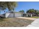 View of the home with a white fence and a large front yard with ample parking space at 10915 Hammock Dr, Largo, FL 33774