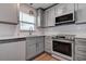 Modern kitchen featuring white cabinets, stainless steel appliances, and subway tile backsplash at 10915 Hammock Dr, Largo, FL 33774