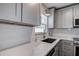 Modern kitchen featuring white cabinets, stainless steel appliances, and white countertops at 10915 Hammock Dr, Largo, FL 33774