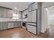 Modern kitchen featuring white cabinets, stainless steel appliances, and hardwood floors at 10915 Hammock Dr, Largo, FL 33774