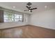 Inviting living room showcasing wood-look floors, a ceiling fan, and a large window at 10915 Hammock Dr, Largo, FL 33774