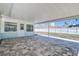 Spacious covered patio features brick pavers and an adjacent yard with a white privacy fence at 10915 Hammock Dr, Largo, FL 33774