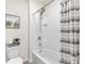 Modern bathroom with a shower-tub combo, stylish shower curtain, and tiled walls at 11617 Miracle Mile Dr, Riverview, FL 33578