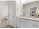 Clean bathroom with a double sink vanity, neutral tones, and a doorway leading to a living space at 11617 Miracle Mile Dr, Riverview, FL 33578