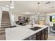 Modern kitchen island featuring a white countertop, stainless steel sink and dark wood cabinetry at 11617 Miracle Mile Dr, Riverview, FL 33578