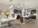Modern kitchen with a large island, bar seating, stainless steel appliances, and a dining area with stylish decor at 11617 Miracle Mile Dr, Riverview, FL 33578