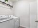 Bright laundry room featuring modern washer and dryer, shelving, and a clean, organized space at 11617 Miracle Mile Dr, Riverview, FL 33578