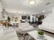 Open-concept living space featuring a modern kitchen, dining area, and living room with stylish white sofas at 11617 Miracle Mile Dr, Riverview, FL 33578