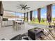 Relaxing screened lanai with a ceiling fan, outdoor furniture, and views of the landscaped backyard at 11617 Miracle Mile Dr, Riverview, FL 33578
