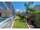 A backyard view features a screened pool, lush landscaping, and a well-maintained lawn that creates a private outdoor space at 12406 Bristol Commons Cir, Tampa, FL 33626