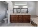 A well-lit bathroom featuring dual sinks, granite countertops, a tub, and modern fixtures at 12406 Bristol Commons Cir, Tampa, FL 33626