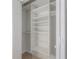 Spacious walk-in closet with white shelving and hanging racks, perfect for storage and organization at 12406 Bristol Commons Cir, Tampa, FL 33626