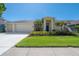 Inviting one-story home featuring a well-manicured lawn and two-car garage at 12406 Bristol Commons Cir, Tampa, FL 33626