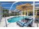 Inviting screened-in pool with lounge chairs and umbrella, creating a relaxing and enjoyable outdoor space at 12406 Bristol Commons Cir, Tampa, FL 33626