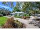 Picturesque walking path featuring a white pergola, lush greenery, and a peaceful ambiance at 12406 Bristol Commons Cir, Tampa, FL 33626