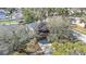 This aerial view showcases a charming home with solar panels, mature trees, and a welcoming driveway at 12705 Longcrest Dr, Riverview, FL 33579