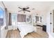 Bright bedroom featuring wood-look flooring, ceiling fan, and large windows at 12705 Longcrest Dr, Riverview, FL 33579
