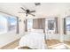 Bright bedroom featuring wood-look flooring, ceiling fan, and large windows at 12705 Longcrest Dr, Riverview, FL 33579