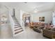 Bright living room with tile flooring, staircase, and an open concept design to the dining area at 12705 Longcrest Dr, Riverview, FL 33579