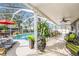 Relaxing screened-in patio with a sparkling swimming pool, comfortable seating, and lush greenery at 12705 Longcrest Dr, Riverview, FL 33579