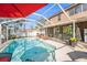 Inviting screened-in pool area with lounge chairs, an umbrella-covered table, and views of the backyard at 12705 Longcrest Dr, Riverview, FL 33579