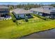Aerial view of the property showcasing a large, fenced backyard with a playset, and proximity to a serene lake at 12730 Oak Hill Way, Parrish, FL 34219